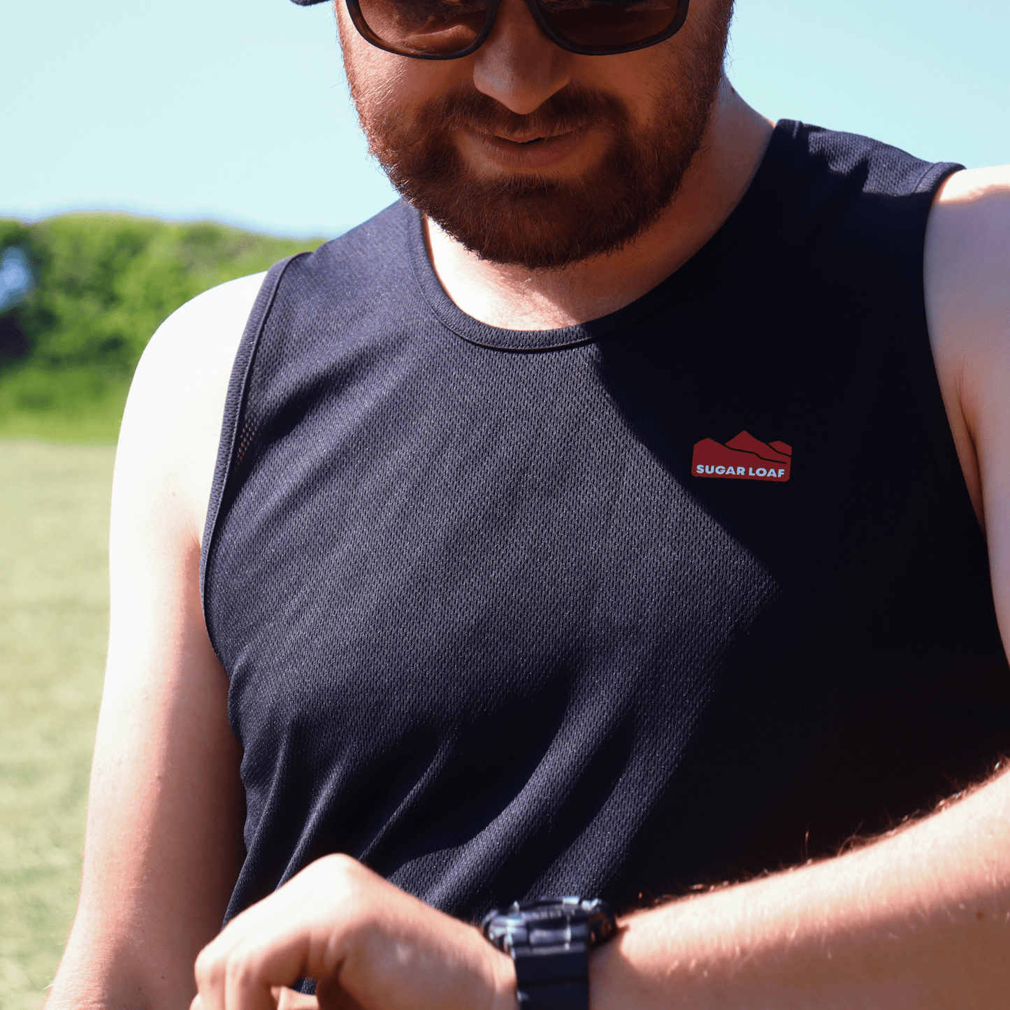 Close up of men's singlet vests and branded Sugar Loaf shearing clothing worn on the farm.