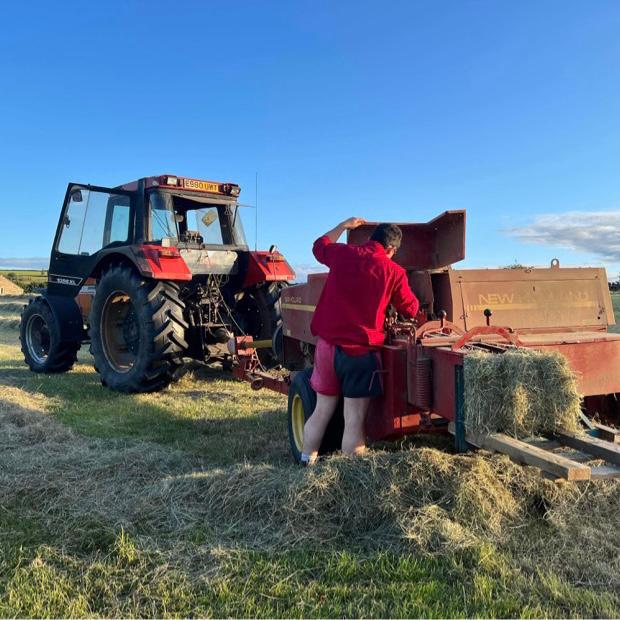 Worker wearing Canterbury harlequin shorts and loading a machine