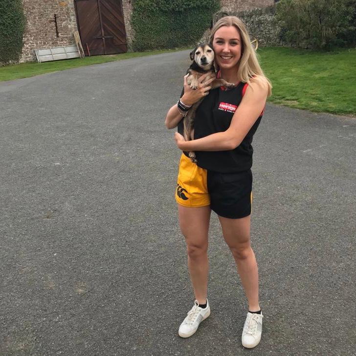 Woman wearing rugby shorts with pockets and holding her dog