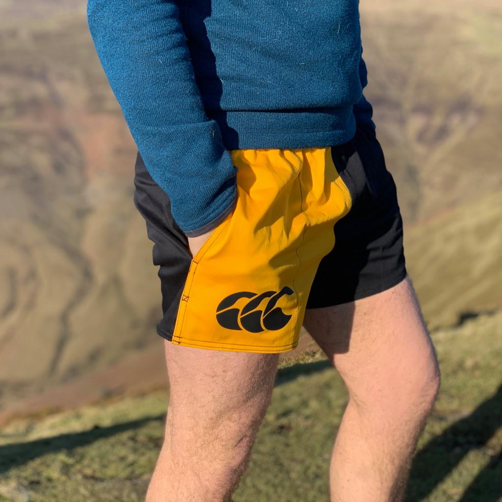Man demonstrating these are rugby shorts with pockets on the side