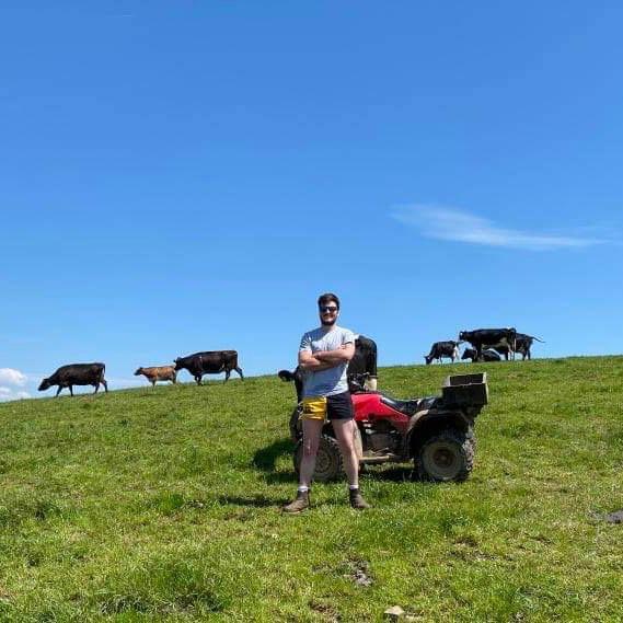 Man wearing clothing for farmers and posing in cattle field