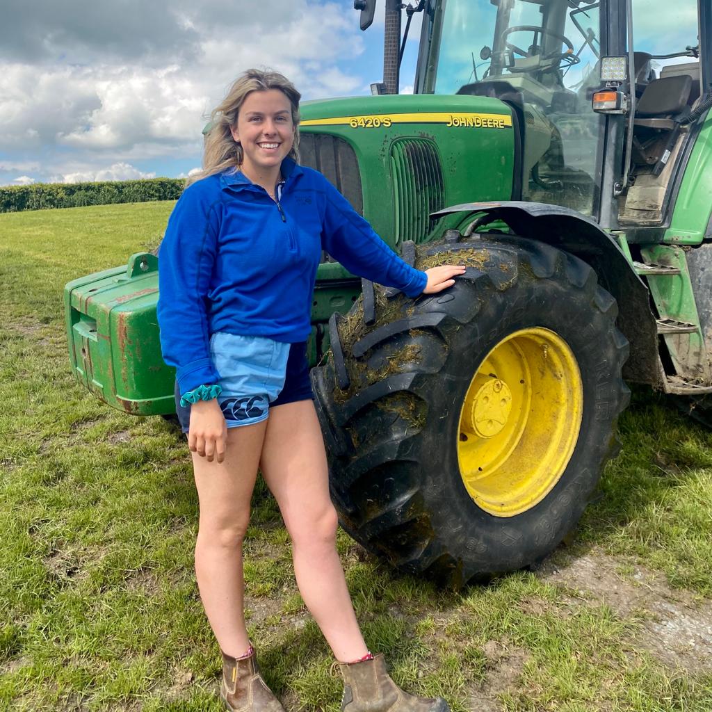 Woman wearing two tone rugby shorts and posing next to a tractor