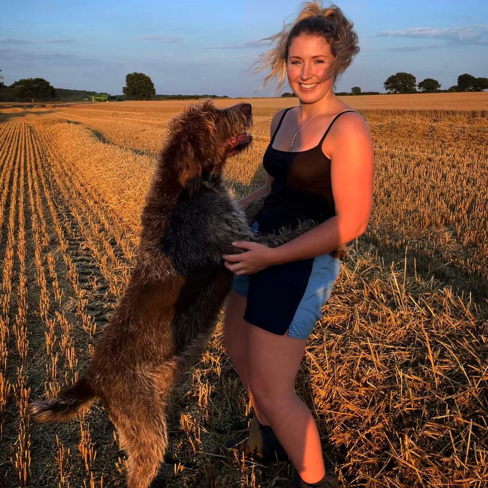 
                  
                    A woman wearing canterbury clothing UK shorts and hugging her dog
                  
                
