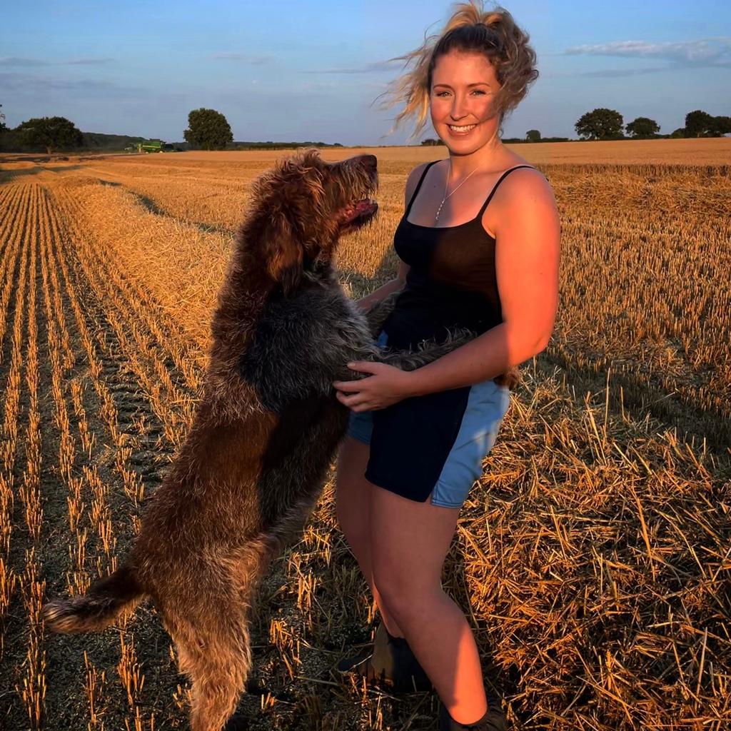 A woman wearing canterbury clothing UK shorts and hugging her dog