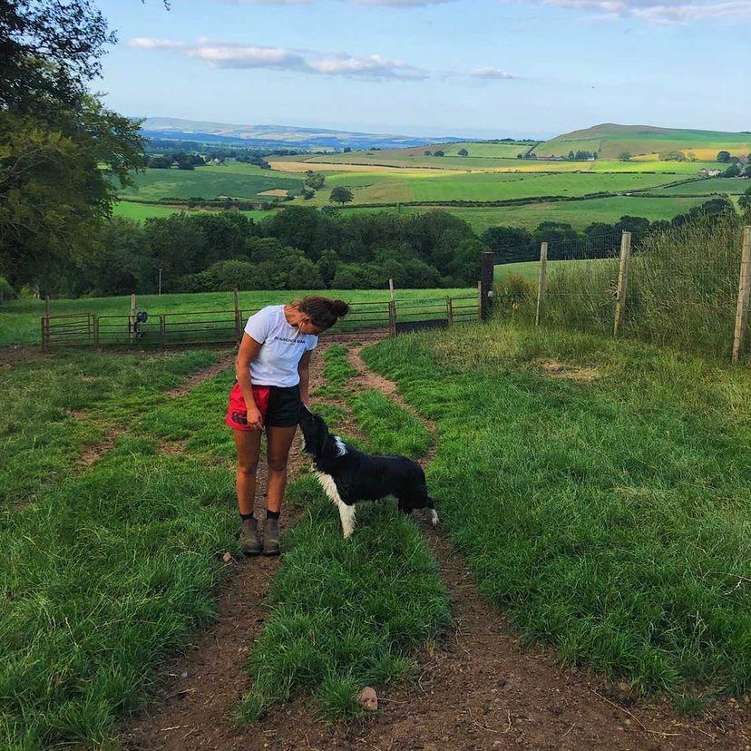Woman wearing scarlet and black Canterbury shorts and petting her dog