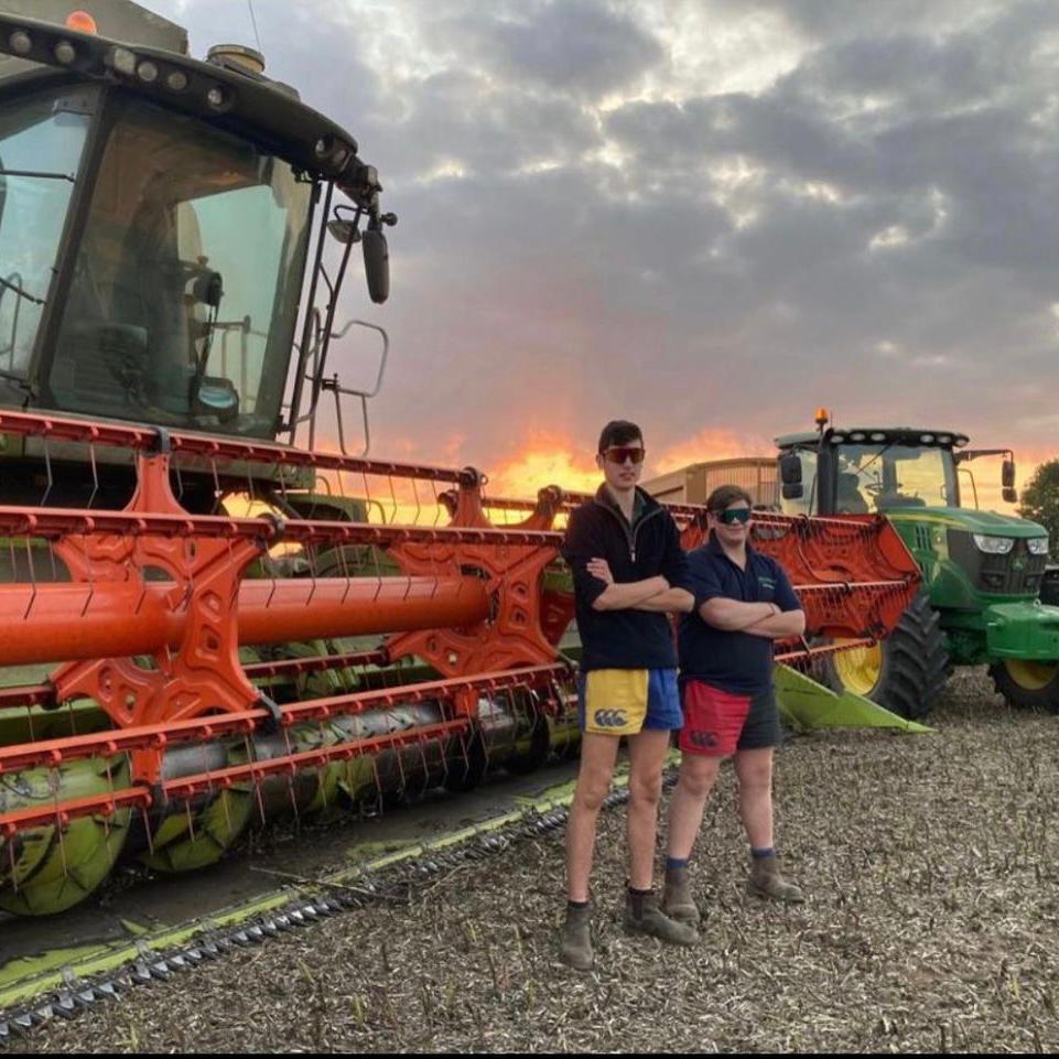Two tractor drivers wearing Canterbury harlequin shorts and standing side by side
