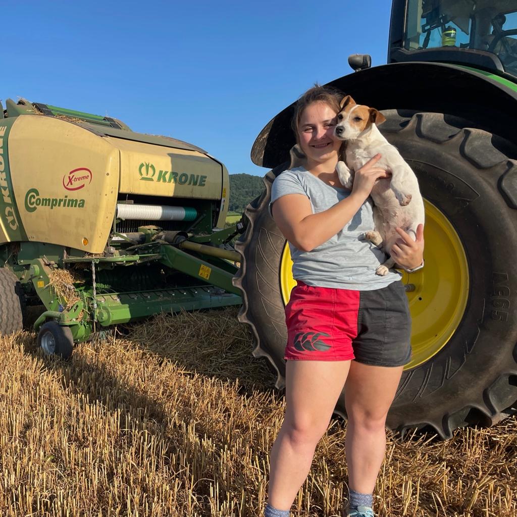 Woman wearing Canterbury harlequin shorts and holding up her small dog