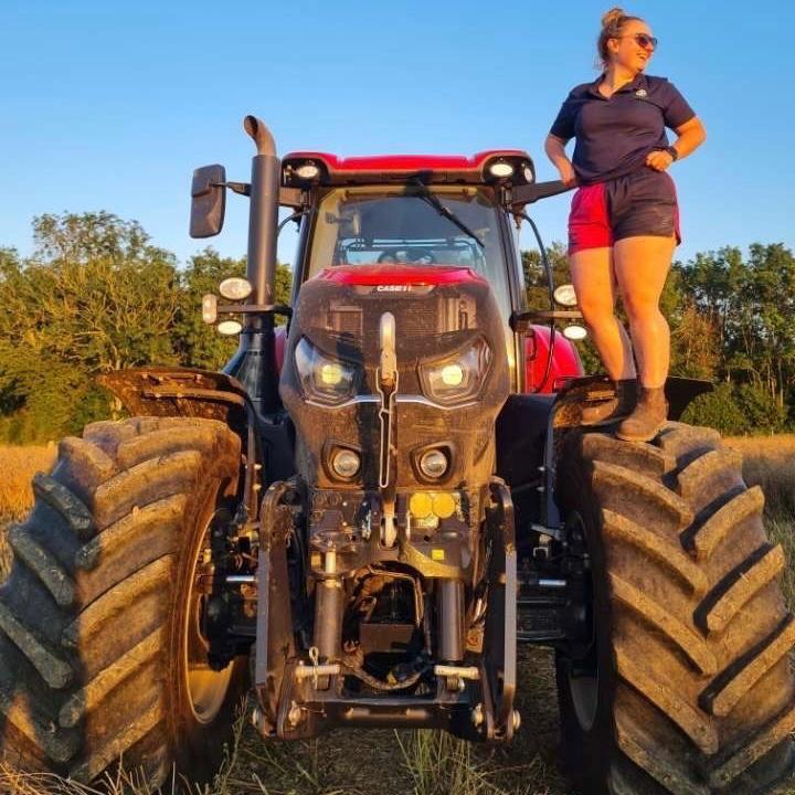 Tractor driver standing on their vehicle and wearing Canterbury rugby shorts with pockets