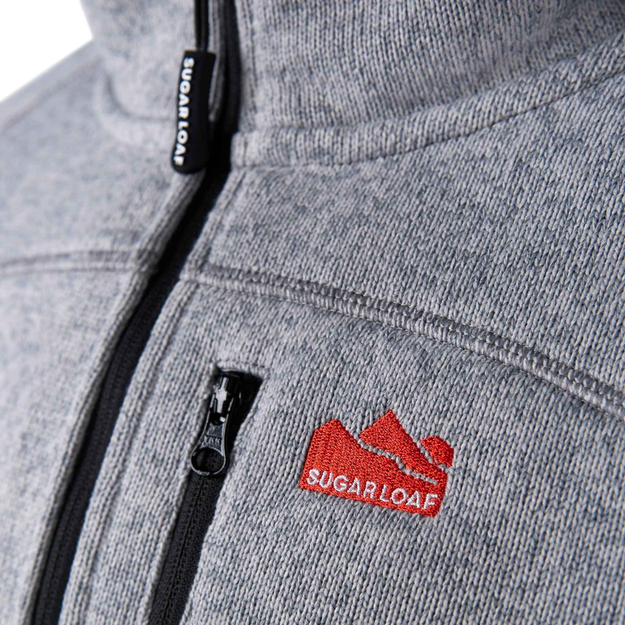 
                    
                      Close-up of embroidered Sugar Loaf logo on the Fell ash grey country fleece.
                    
                  