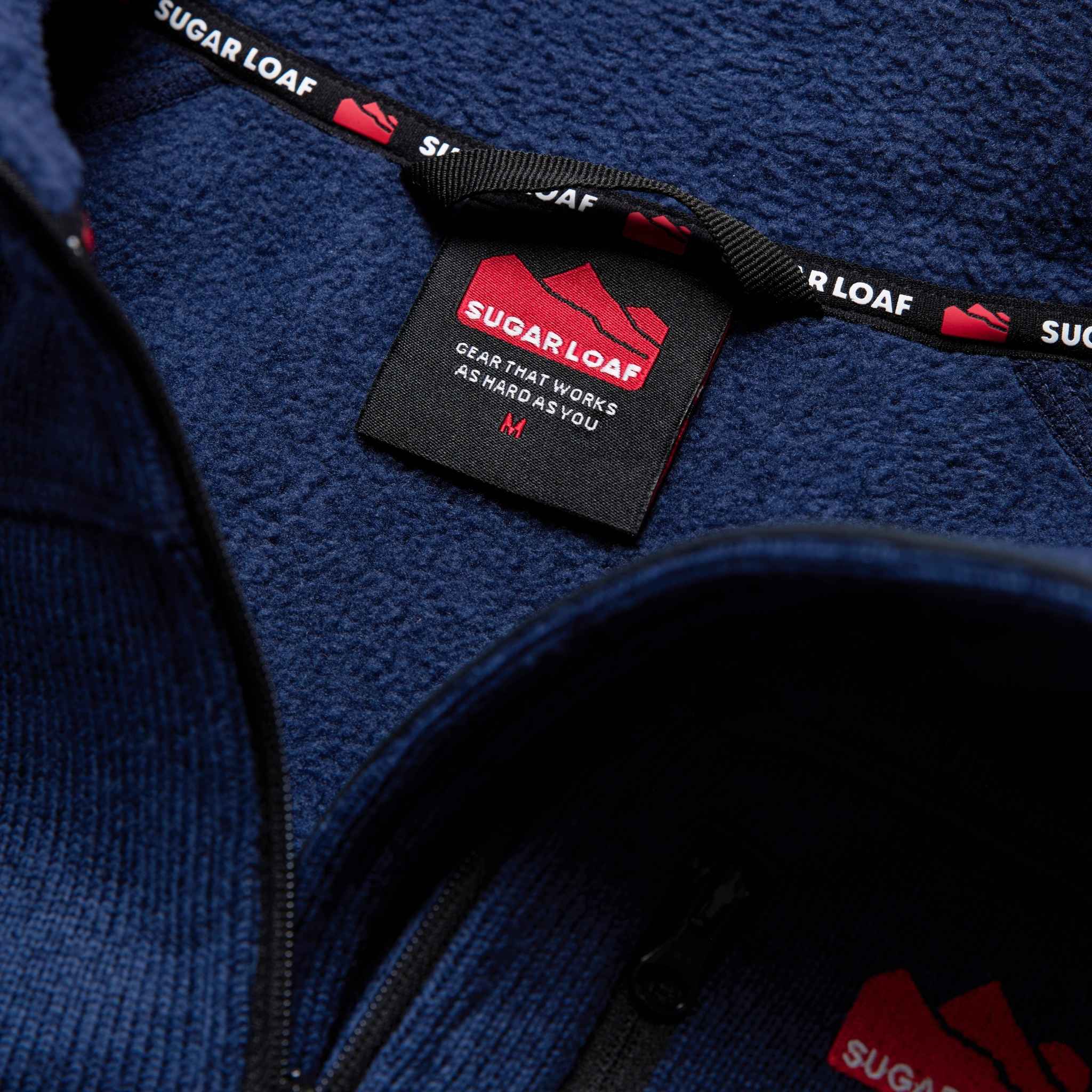 
                    
                      Neck hanger detail on the Sugar Loaf Fell farming fleece, practical feature for agricultural clothing.
                    
                  