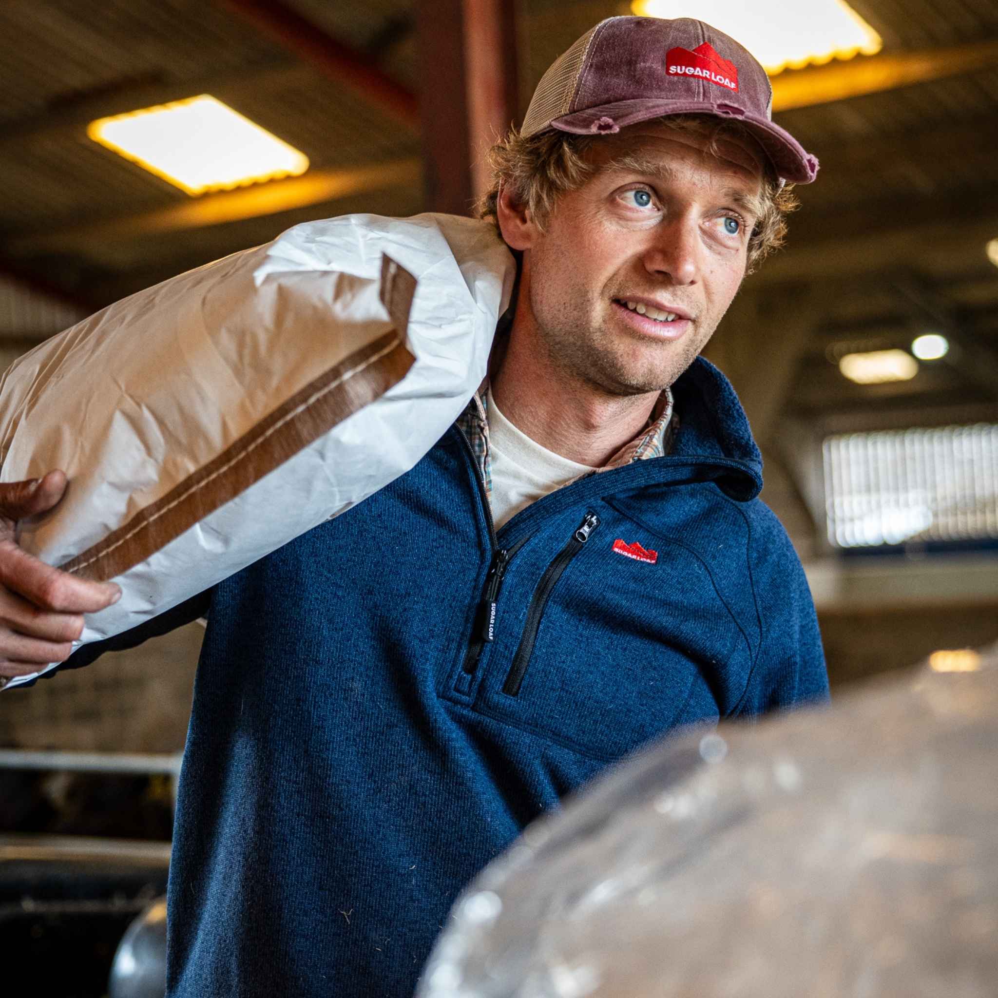 Farmer wearing Sugar Loaf Fell Half Zip Fleece in navy, rugged farming clothes for outdoor work