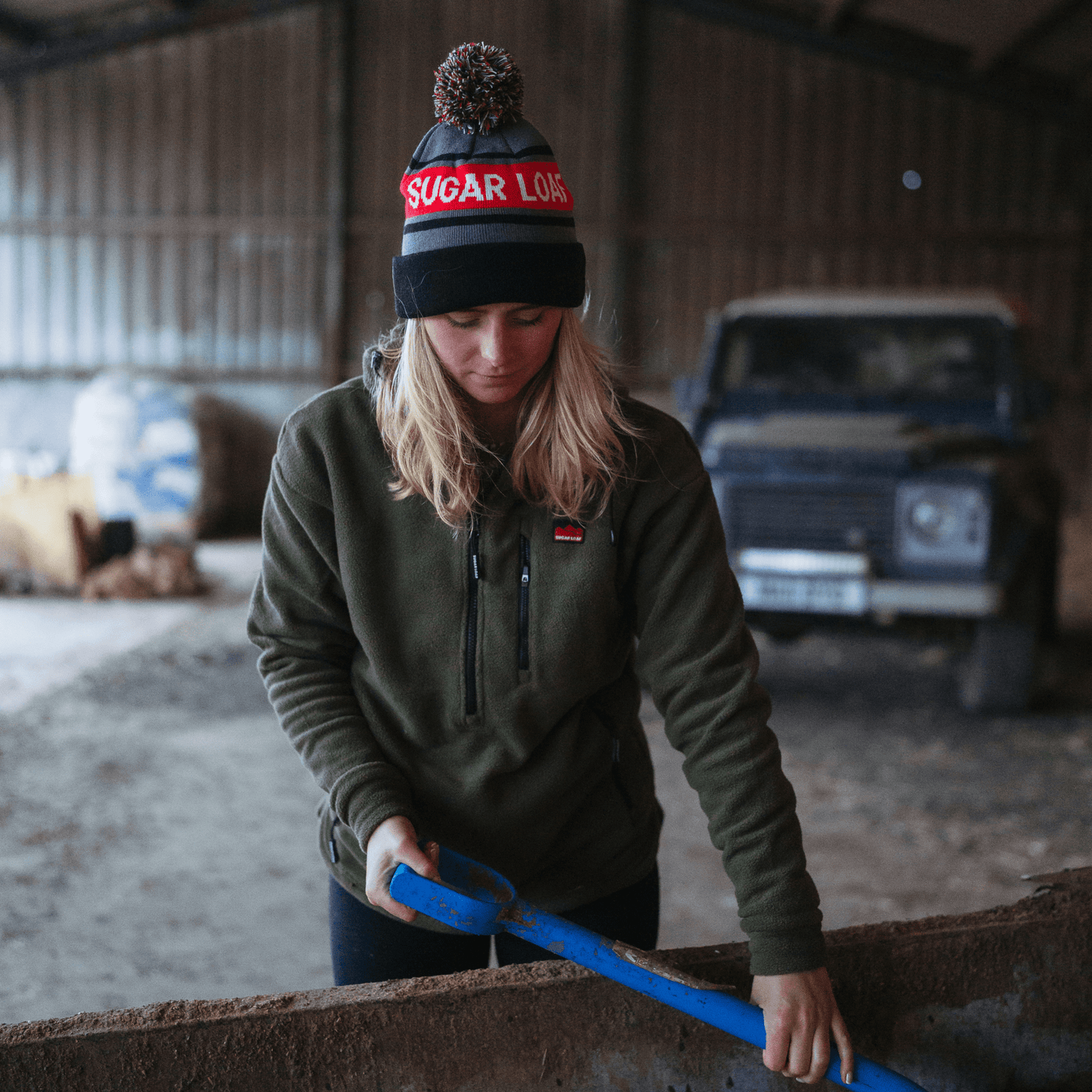Farmer working in the Sugar Loaf Shepherd Hoodie, dependable farm wear for cold conditions.