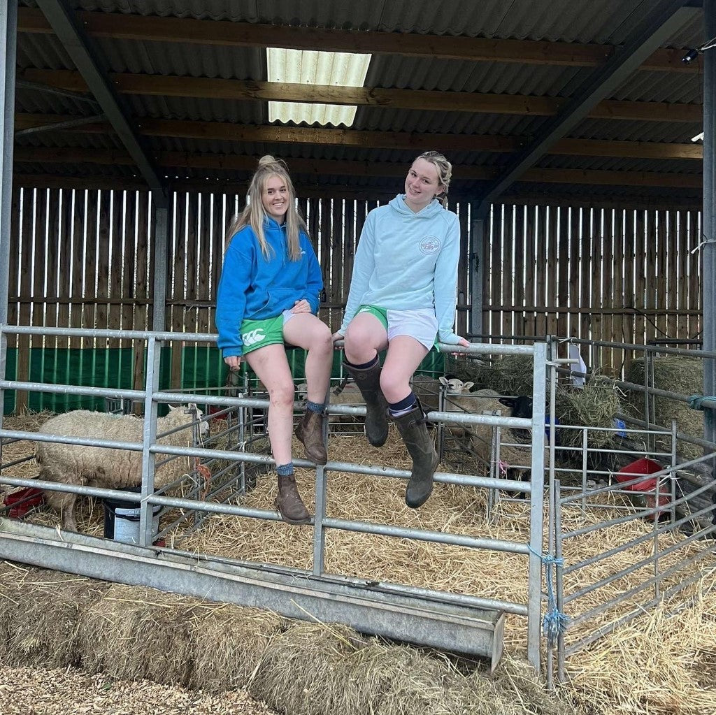 
                  
                    Two women wearing the Canterbury Clothing UK range and sitting on a fence
                  
                